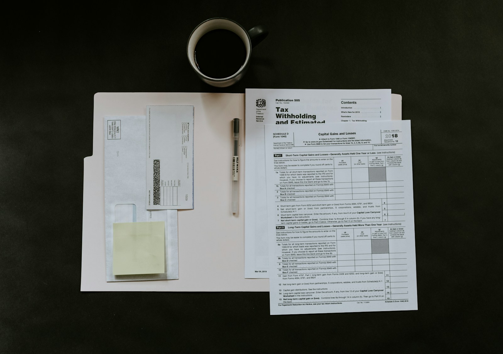 税務関連の書類とコーヒーカップ。届出・インボイス手続きのイメージ